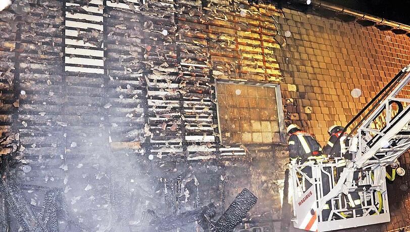 Feuerwehrleute bekämpfen von einer Drehleiter aus die letzten Flammen an einem Einfamilienhaus in Taufkirchen. Feuerwehrleute bekämpfen von einer Drehleiter aus die letzten Flammen an einem Einfamilienhaus in Taufkirchen.