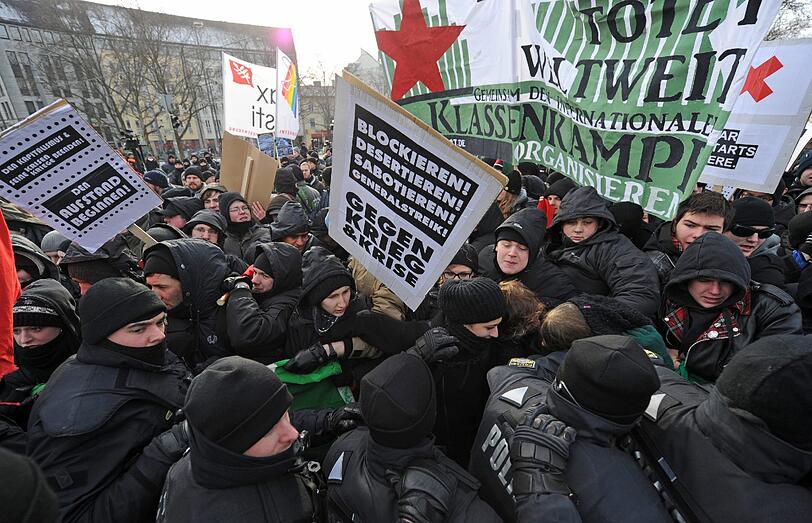 Es kommt zum Gerangel zwischen Demonstranten und der Polizei. Die Polizei greift nach den Demonstranten.